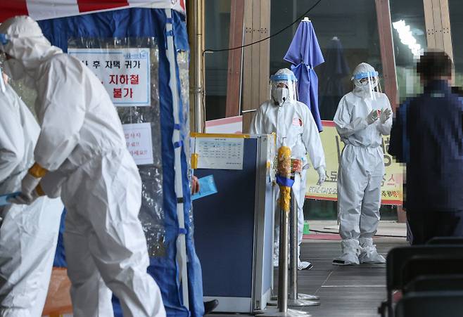 11일 서울 송파구 보건소에 설치된 신종 코로나바이러스 감염증(코로나19) 선별검사소에서 방호복을 입은 관계자들이 분주하게 업무를 하고 있다. 연합뉴스