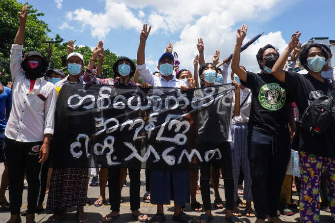 12일 미얀마 양곤에서 시위대가 저항의 상징인 ‘세 손가락’을 들고 외치고 있다.(사진=AFP제공)
