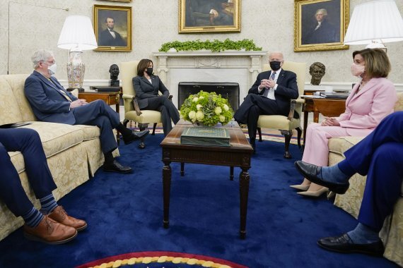 조 바이든 미국 대통령(오른쪽에서 세번째)이 12일(현지시간) 취임 후 처음으로 백악관에서 여야 지도부와 회동한 자리에서 깍지를 끼고 있다. 바이든 대통령 왼쪽 옆은 카멀라 해리스 부통령, 오른쪽 옆은 민주당 낸시 펠로시 하원의장. AP뉴시스
