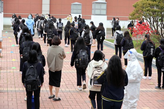 지난달 22일 오후 광주 북구의 한 고등학교에서 학생과 교직원 등이 코로나19 검사를 받기 위해 줄 서있다.뉴스1