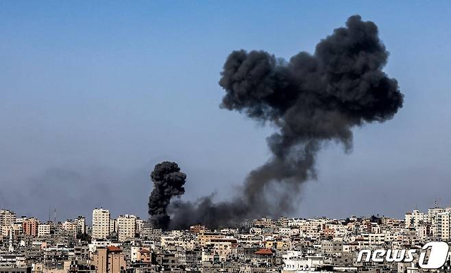 12일(현지시간) 팔레스타인 무장 정파 하마스가 지배하는 가자지구에서 이스라엘군의 공습으로 화염과 검은 연기가 치솟고 있다. © AFP=뉴스1 © News1 우동명 기자