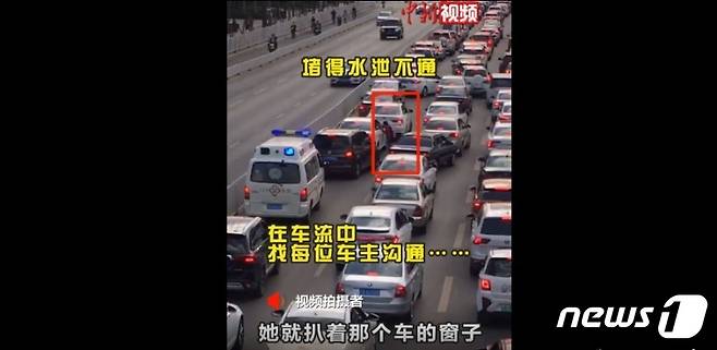 중국 쿤밍에서 응급차량이 교통 체증에 도로에 갇히자 한 소녀가 차량 문을 두드리면서 길을 열고 있다(중국 웨이보 갈무리)© 뉴스1