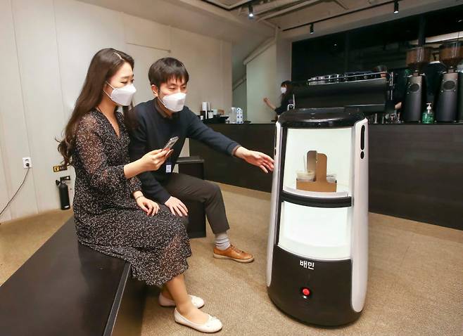 D타워 광화문에서 배달로봇 딜리타워로 커피 배달을 시연하고 있다.