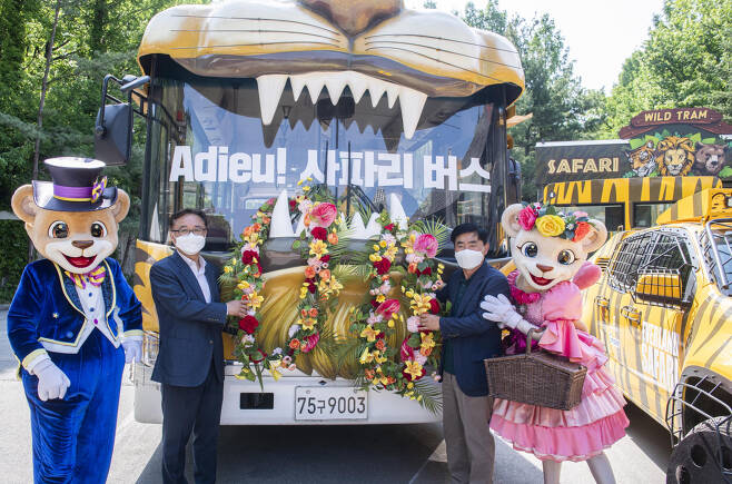 삼성물산 리조트사업부장 정병석 부사장(왼쪽)과 박광월 전 사육사가 은퇴하는 사파리 버스 앞에서 기념 촬영을 하는 모습