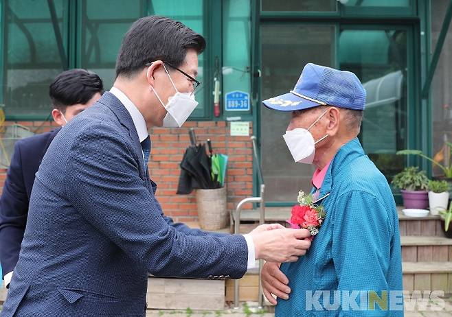 양승조 충남도지사가 광풍중학교 유광석 은사(오른쪽)를 만나 꽃을 달아드리는 모습.