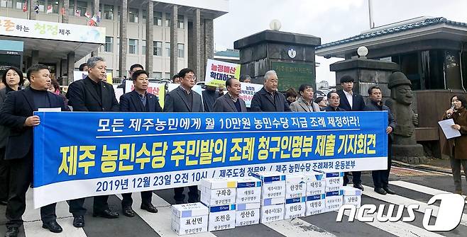 제주 농민수당 심의위원회가 오는 26일 도청에서 회의를 열고 '농민수당 지원계획'에 대해 논의한다. 제주 농민단체로 구성된 ‘제주 농민수당 조례 제정 운동본부’가 지난해 제주도청 정문 앞에서 기자회견을 열고 있다..2019.12.23/뉴스1© News1