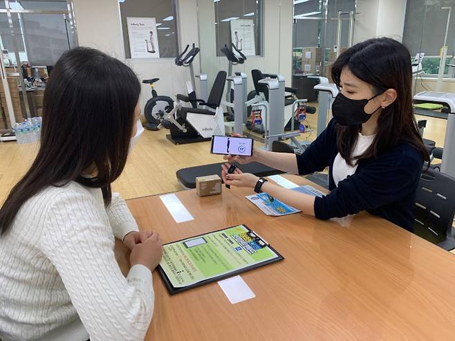 서울 금천구보건소 직원이 ‘비대면 스마트 비만관리 서비스’ 참여자에게 스마트 기기 사용방법을 설명하고 있다. 금천구 제공