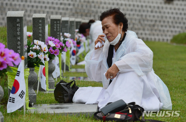 [광주=뉴시스] 김혜인 기자 = 5·18민주화운동 41주기를 하루 앞둔 17일 광주 북구 운정동 국립 5·18민주묘지에서 한 어머니가 열사 묘 앞에 주저앉아 눈물을 흘리고 있다. 2021.05.17. hyein0342@newsis.com