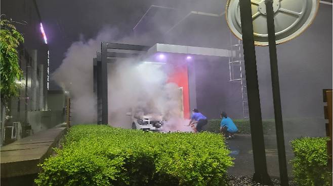 패스트푸드점 드라이브스루에서 외제차에서 불이나 직원들이 진압하고 있다. 독자제공