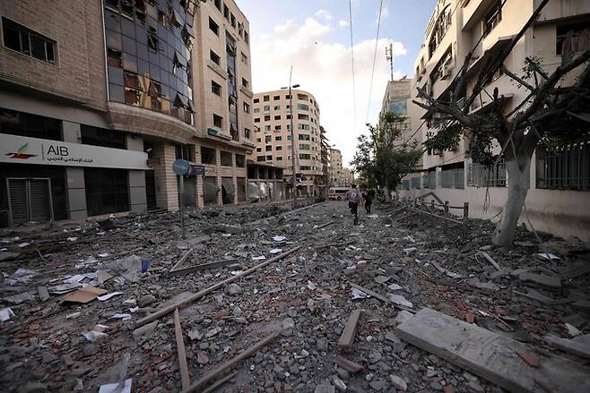 17일 이스라엘군의 공습을 받아 파괴된 가자지구 거리에 한 구조대원이 뛰어가고 있다. 가자지구/AFP 연합뉴스