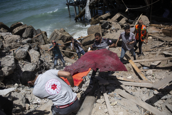 구급대원들이 17일(현지시간) 팔레스타인 가자지구의 무너진 건물에서 사망자를 나르고 있다. 이스라엘과 하마스가 지난 10일부터 충돌하며 사망자는 200명을 넘겼다. 유엔 안전보장이사회는 이날 무력 행위에 반대하는 성명을 내려했지만 채택이 무산됐다.  AP연합뉴스