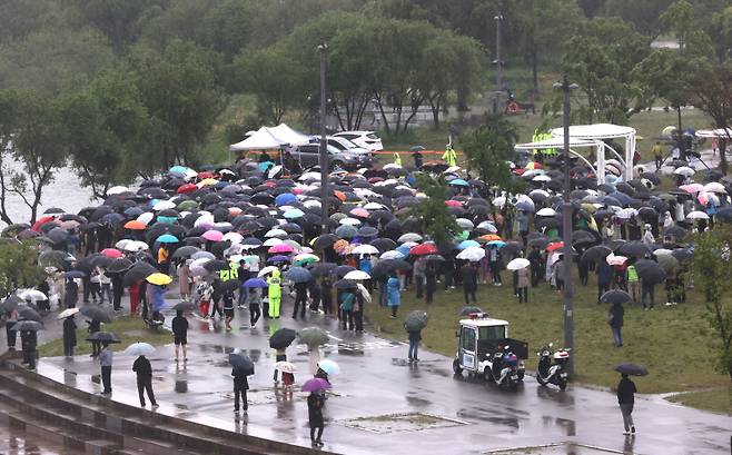 지난 16일 오후 서울 반포한강공원 수상택시 승강장 인근에서 열린 `고 손정민 군을 위한 평화집회`에서 참가자들이 우산을 쓴 채 자리를 지키고 있다. [사진 출처 = 연합 뉴스]