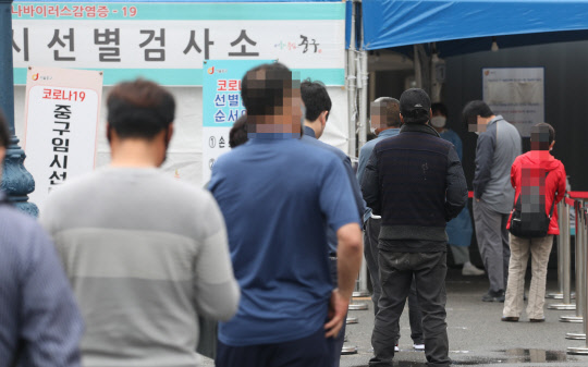 지난 18일 서울역 임시선별검사소에서 시민들이 차례를 기다고 있다. <연합뉴스>