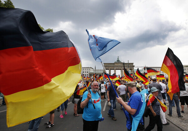 Supporters of the right-wing nationalist party Alternative for Germany hold the party flag in front of the Brandenburg Gate in Berlin, Germany, on May 27, 2018. (AP/Yonhap News)