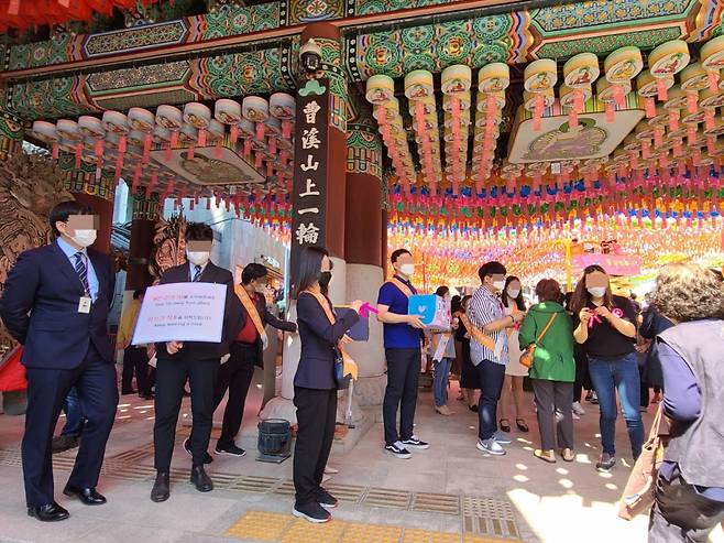 19일 서울 수송동 조계사에서 열린 법요식에서 행사요원들이 신도들에게 방역 지침을 안내하고 있다. /사진=정한결 기자