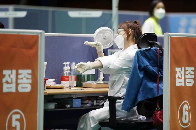 20일 오후 광주 북구 코로나19 화이자 백신 접종예방센터에서 북구 보건소 의료진이 접종 도중 잠시 스트레칭을 하며 몸을 풀고 있다. 광주 북구청 제공, 연합뉴스