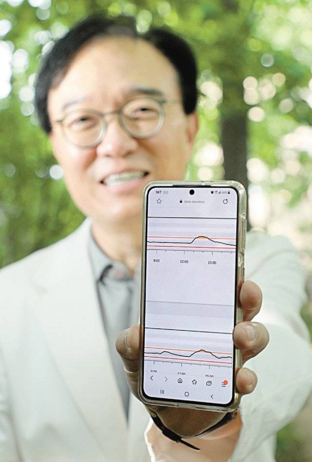 최 교수가 혈당 수치가 뜬 휴대전화 화면을 들어보이고 있다.