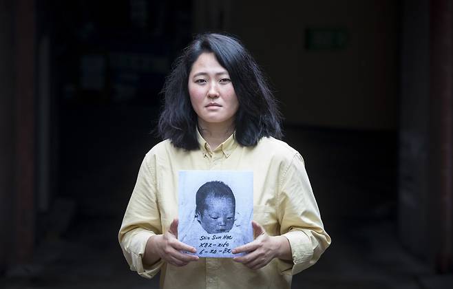 입양 문제를 다룬 다큐멘터리 영화 '포겟 미 낫(Forget Me Not)'을 만든 선희 엥겔스토프(덴마크) 감독이 지난 21일 입양 당시 사진을 들고 서 있다. 이름과 생년월일이 보인다. /김지호 기자