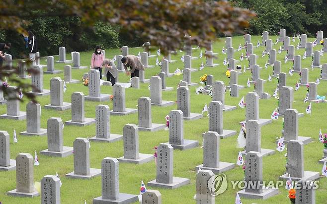 현충일을 기리며 (서울=연합뉴스) 진성철 기자 = 제66회 현충일을 하루 앞둔 5일 서울 동작구 국립서울현충원에서 유가족들이 묘비를 찾아 절하고 있다. 2021.6.5 zjin@yna.co.kr