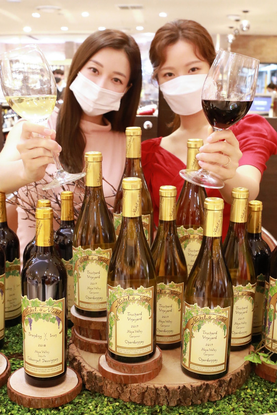 Models pose with four types of Nickel & Nickel wine at Lotte Department Store's main branch in central Seoul on Sunday. Nickel & Nickel is a single vineyard winery under Far Niente, a premium winery located in Napa Valley, California. [LOTTE DEPARTMENT STORE]