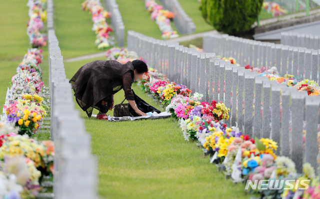 [임실=뉴시스]김얼 기자 = 현충일을 맞이한 6일 전북 임실군 호국원을 찾은 한 성묘객이 묘비 앞에서 고인의 넋을 기리고 있다. 2021.06.06. pmkeul@newsis.com