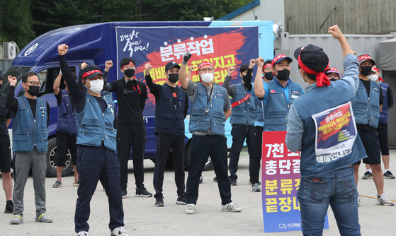 Members of Taekbae Union, which represents delivery workers, protest in front of a logistics center in Yongin, Gyeonggi, on Monday. Members are demanding companies to allow delivery workers to start their work at 9 a.m. in the morning and start delivery at 11 a.m. [NEWS1]