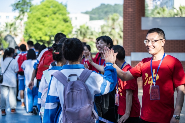 중국 남서부 구이저우 성 구이양 시의 한 고등학교 시험장에서 교사들이 수험생들과 손뼉을 치고 있다. '가오카오'로 더 잘 알려진 중국의 연례 대학 입학시험이 7일 월요일 아침 1078만명의 응시자와 함께 시작됐다.  신화통신뉴시스