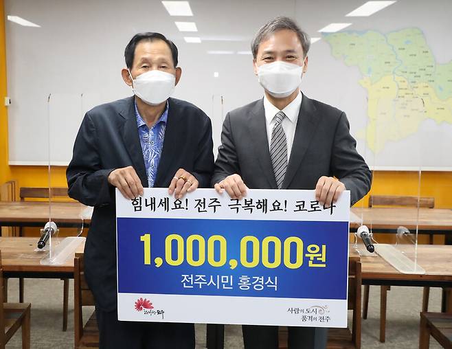 70대 홍경식(왼쪽)씨가 지난해에 이어 올해도 폐지를 팔아 모은 돈 100만원을 김승수 전주시장을 통해 기부했다. 전주시 제공
