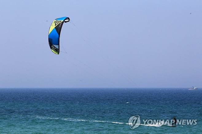 바람에 몸을 싣고 초여름 날씨를 보인 지난 6일 강릉 송정해변을 찾은 카이트보드 동호인들이 바다 위를 질주하며 휴일을 즐기고 있다. [연합뉴스 자료사진]