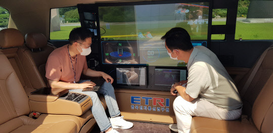 ETRI 연구진이 개발한 자율주행 셔틀버스 '오토비' 내부에 설치된 투명 OLED 디스플레이에서 탑승자들이 AR 실감 콘텐츠를 시연하고 있다. ETRI 제공