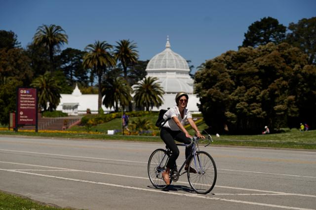 미국 캘리포니아주 샌프란시스코의 한 공원에서 한 여성이 지난 4월 28일 자전거를 타고 있다. 샌프란시스코=AP 연합뉴스