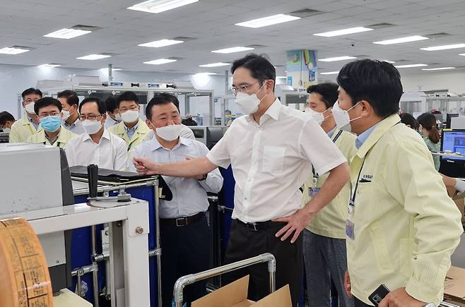Lee checks out at smartphone products at Samsung's plant in Hanoi, Vietnam in 2020. (Samsung Electronics)