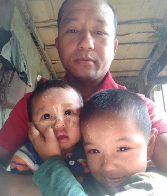 지난달 24일 미얀마 사가잉주에서 고문사한 오토바이 정비공 민 민(가운데)의 생전 모습. 그의 품에서 어린 두 아들이 해맑게 웃고 있다. 미얀마 나우 캡처