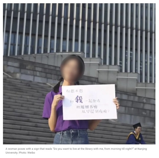 중국 난징대가 지난 7일 웨이보에 올린 대학 광고 사진으로, 한 여학생이 “나랑 하루종일 도서관에 있을래?"라고 적힌 팻말을 들고 있다. 사우스차이나모닝포스트 홈페이지 캡처 뉴시스