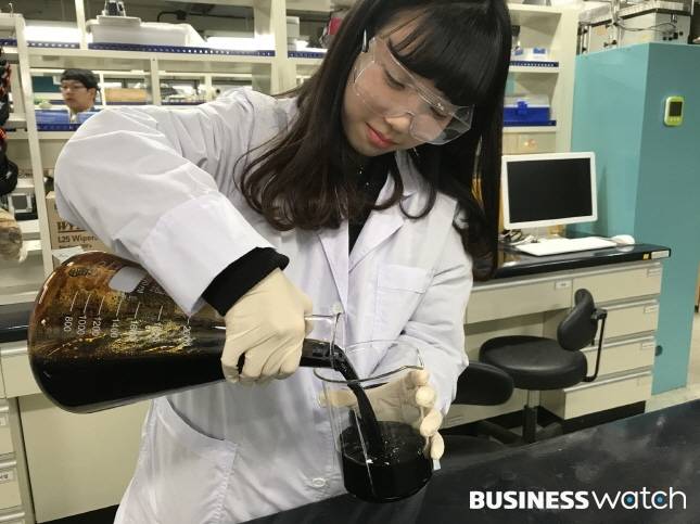 펄프를 생산하고 남은 흑액으로 한 연구원이 실험을 진행하고 있다./사진=국립산림과학원 제공