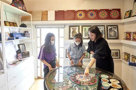 김도래 대표가 제작한 작품에 대한 설명을 듣고 있는 소중 학생기자단.