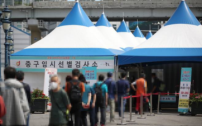 14일 오전 서울역 광장에 마련된 중구임시선별검사소에서 시민들이 코로나19 선별검사를 받기 위해 줄을 서 있다. 연합뉴스