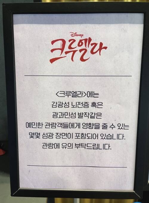 영화 '크루엘라'의 상영관에 광과민성증후군 주의 문구가 붙어있는 모습./사진=인터넷 커뮤니티 캡처
