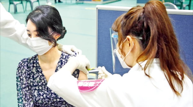 국내 코로나19 백신 접종률이 전 국민의 25%를 넘어섰다. 15일 광주 북구에 있는 예방접종센터에서 한 여성이 화이자 백신을 접종받고 있다.   연합뉴스