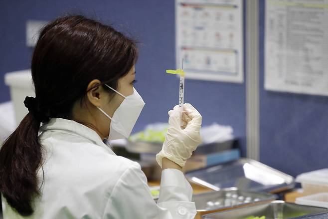 A medical worker prepares to administer a shot at a public COVID-19 vaccination center. (Yonhap)