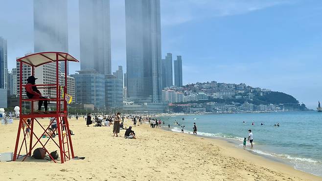 People in face masks are seen at a beach in Haeundae, Busan, on Sunday. (Yonhap)