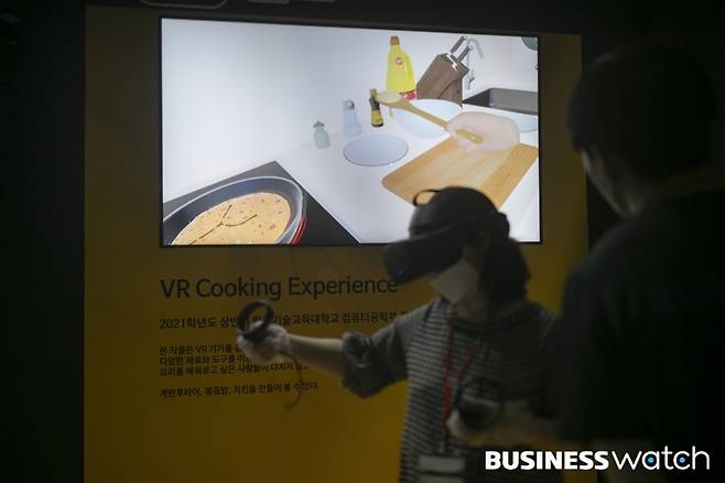 18일 서울 강남구 코엑스에서 열린 '2021 서울 가상증강현실 박람회'를 찾은 관람객들이 VR 쿠킹 체험을 하고 있다.  /사진=이명근 기자 qwe123@
