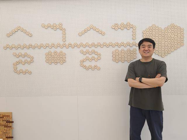 해빗투게더협동조합의 박영민 상무이사가 9일 서울 마포구 성산동 '모두의 놀이터'에서 포즈를 취하고 있다. 벽에는 출자한 조합원들의 이름이 새겨진 나무판이 붙어있다. 이유지 기자