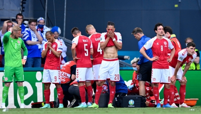 덴마크 축구대표팀 선수들이 13일 코펜하겐 파르켄 스타디움에서 열린 유로 2020 핀란드전에서 쓰러진 에릭센의 모습을 가리고자 그를 둘러싼 채 서있다. AP뉴시스