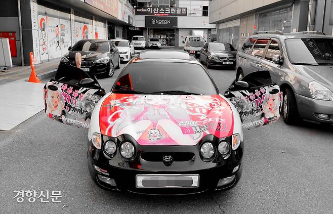 ‘주차혐오’ 논란이 되었던 차량. 구형 티뷰론에 게임 ‘벽람항로’ 캐릭터 허먼을 래핑한 것이었다. 누리꾼 댓글을 보면 ‘혐오할만 하다’는 반론도 만만치 않다. 이 차는 그 뒤 더이상 운용되지 않고, 경기도 광주의 한 튜닝전문샵 앞에 전시되어 있다./트위터