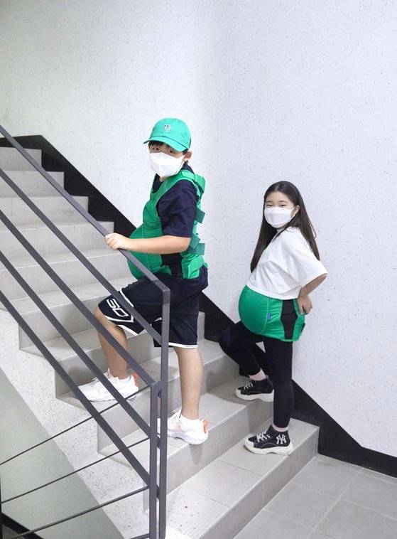 임산부 체험복을 입어본 한현(왼쪽) 학생기자와 이서정 학생모델. 온몸을 짓누르는 무게에 “엄마가 우릴 임신했을 때 얼마나 힘들었을지 짐작 간다”며 입을 모았다.