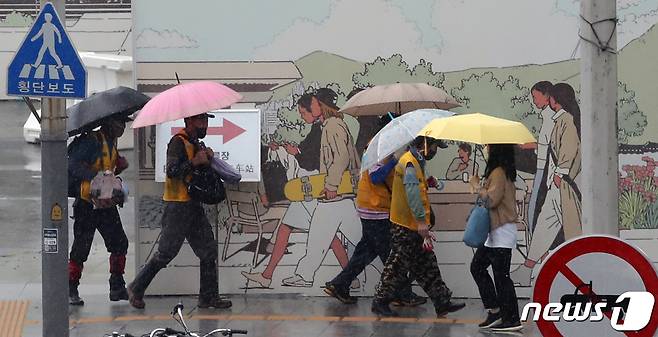 소나기가 쏟아진 23일 오후 서울 종로구 정부서울청사 인근 인도에서 시민들이 걸음을 재촉하고 있다. 2021.6.23/뉴스1 © News1 송원영 기자