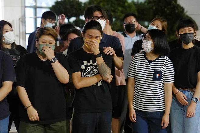2021년 6월 24일 홍콩 빈과일보 기자들이 사옥 앞에 모인 독자와 지지자들을 향해 감사와 작별 인사를 고하며 울먹이고 있다. /연합뉴스