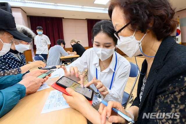 [서울=뉴시스]정병혁 기자 = 2일 서울 양천구 목3동 주민센터에서 관계자들이 어르신들에게 스마트폰 활용 방법을 소개하고 있다. 사진은 기사와 무관. (사진=양천구 제공) 2021.06.02. photo@newsis.com