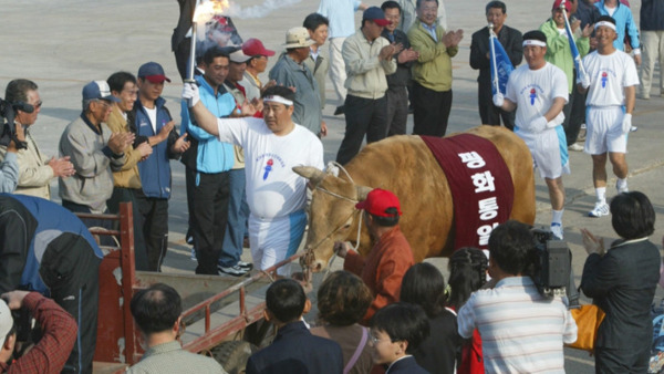 <사진2: 2005년 제주도민 체육대회 성화봉송 주자로 나선 '평화통일의 소'>